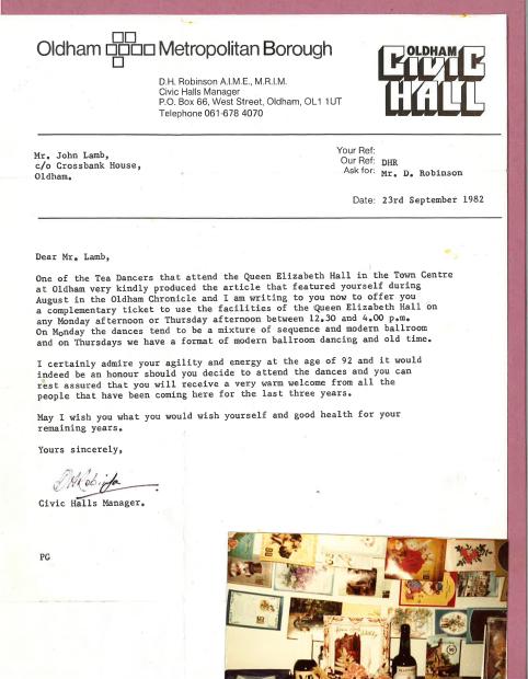 A scan of a letter from Oldham Civic Halls’ Manager to Mr John Lamb, living at Crossbank House. The letter reads “Dear Mr. Lamb, One of the Tea Dancers that attend the Queen Elizabeth Hall is in the Town Centre at Oldham very kindly produced the article that featured yourself during August in the Oldham Chronicle and I am writing to you now to offer you a complementary ticket to use the facilities of the Queen Elizabeth Hall on any Monday afternoon or Thursday afternoon between 12.30 and 4.00 p.m. On Monday the dances tend to be a mixture of sequence and modern ballroom and on Thursdays we have a format of modern ballroom dancing and old time. I certainly admire your agility and energy at the age of 92 and it would indeed be an honour should you decide to attend the dances and you can rest assured that you will receive a very wam welcome from all the people that have been coming here for the last three years. May I wish you what you would wish yourself and good health for your remaining years. Yours sincerely [signature of D.H. Robinson] Civic Halls Manager.” The letter is on headed paper from Oldham Metropolitan Borough and Oldham Civic Hall. The scan is backed with a pink card, and has a photo in the bottom right corner of a wall with lots of cards pinned to it.